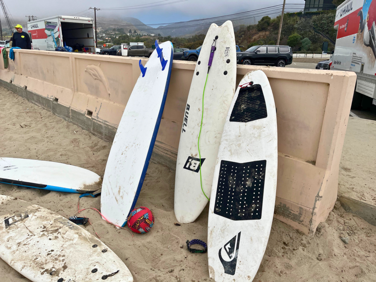 Surf boards propped against a beach wall.